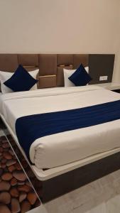 een groot bed met blauwe en witte lakens en kussens bij Hotel Basant Orchha in Orchha +46 foto's