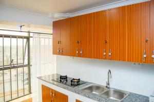 a kitchen with wooden cabinets and a sink at The Mark Hotel in Ruiru +19 photos