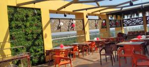 a restaurant with tables and chairs and plants at HOTEL SILVERA GRAND in Ahmedabad
