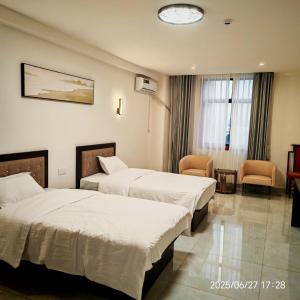 a hotel room with two beds and a chair at Jiang Su Hotel in Brazzaville