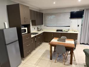 a small kitchen with a table and a refrigerator at Bushview cottage 