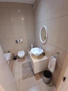 Un baño con lavabo, inodoro y espejo. en Stylish 3BR Apartment Monks View Plettenberg bay, en Plettenberg Bay 21 fotos más