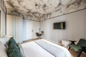 Un dormitorio con una cama y un techo cubierto de nubes. en Suites Madrid Centro, en Madrid