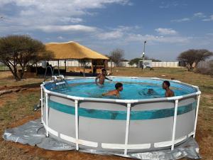 a group of people in a circular pool in a yard at Shumba Camping Site in Mahikeng