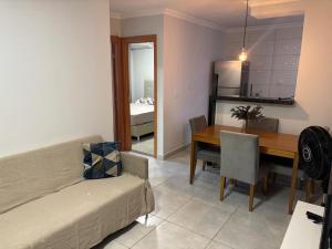 a living room with a couch and a dining room at Apartamento próximo ao Porto Cuiabá e orla VG in Várzea Grande