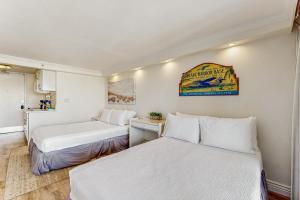 two beds in a small room with white walls at Island Colony 3414 - 30-Night Minimum in Honolulu +25 photos