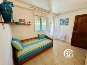 a bed in a room with a window at Le gite turquoise in Narbonne-Plage