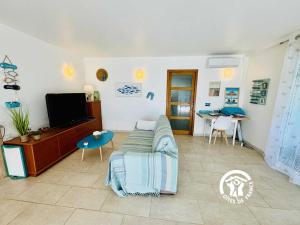 a living room with a couch and a tv at Le gite turquoise in Narbonne-Plage