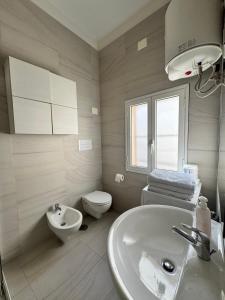 een witte badkamer met een wastafel en een toilet bij Casetta Silvia in Brindisi