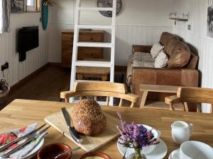 a living room with a table and a couch at Shepherds Cabin at Titterstone in Farden