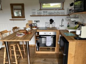 a kitchen with a counter and a table with an oven at Shepherds Cabin at Titterstone in Farden
