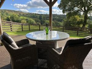 a table with a bottle of wine sitting on a patio at Shepherds Cabin at Titterstone Hot Tub & Dog-Friendly near Ludlow in Farden