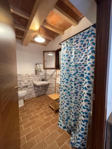 a bathroom with a shower curtain and a sink at Agriturismo Santa Lorica - Sassetta in Sassetta