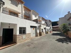 een rij witte gebouwen aan een straat bij Nevada Suites Guejar in Güéjar-Sierra