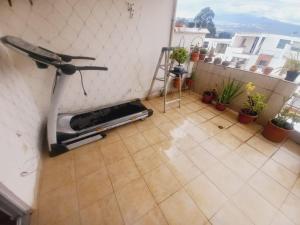 Una habitación con una cinta de correr en un piso con plantas. en Casa De la Cruz, en Quito 6 fotos más