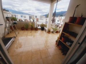 Una vista de una habitación con plantas en macetas en un balcón. en Casa De la Cruz, en Quito