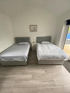 two beds in a bedroom with a tile floor at Magnificent Views over Dungarvan Bay, Ring, Waterford , Panoramic Sea Views, in Dungarvan