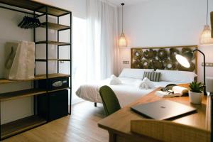 a bedroom with a bed and a desk with a laptop at Outsite Ibiza in Es Cana +32 photos