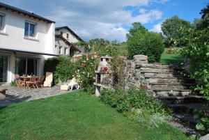 a garden with a stone wall and a house at la belle étape in Osséja