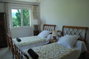two beds in a room with a window at la belle étape in Osséja