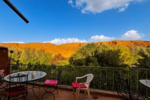 a balcony with a table and chairs and mountains at DAR Moha dades in Aït Ougliff