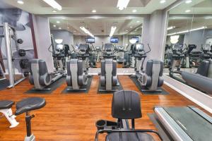 a gym with lots of treadmills and machines at Well-Equipped Apartment Close to Metro Station in Addison Heights
