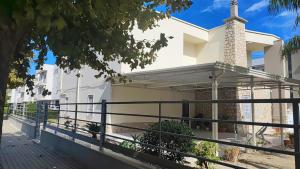 a white house with a black fence at Afrodite Affittacamere in Metaponto +7 photos