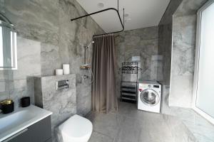 a bathroom with a washing machine and a washer at Svaja ApartHotel in Šiauliai +124 photos
