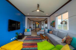 a living room with a couch and a tv at AltaVista 4C 3 bdr Ocean View in Los Suenos in Herradura