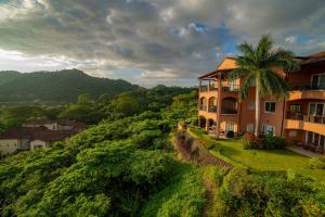 une maison sur une colline avec un palmier dans l'établissement AltaVista 5A 3 bdr Ocean View in Los Suenos, à Herradura