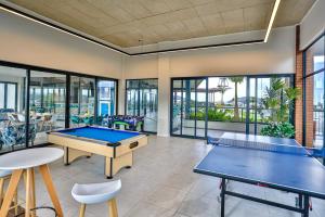 a living room with two ping pong tables and windows at Ballito Hills 369 in Ballito