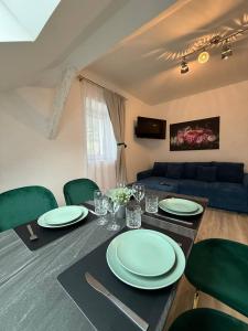 a dining room table with green chairs and a blue couch at Family Apartments Zemlinsi 2 in Payerbach