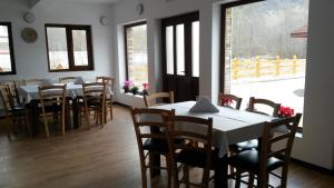 Green Eden Lepsa في ليبسا: غرفة طعام مع طاولات وكراسي ونوافذ