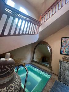 una piscina en una casa con espejo en Riad Jamaique - Marrakech, en Marrakech