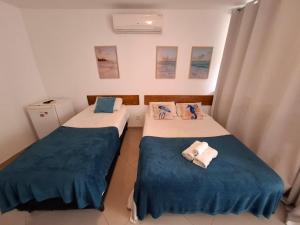 two beds in a room with blue and white at POUSADA PARAISO da BARRA DA TIJUCA in Rio de Janeiro +52 photos