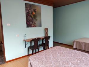 a room with a table and two chairs and a bed at Mashpi Amagusa Lodge in Mashpi