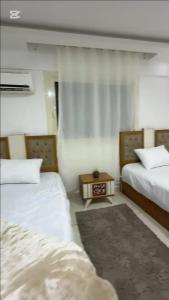 Habitación de hotel con 2 camas y alfombra en KHadma vip, en Banī Ghālib