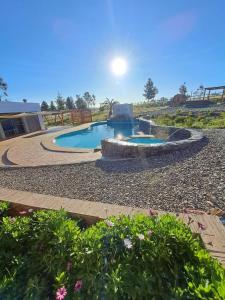 a swimming pool with a fountain in a yard at Quillon Cabaña Privada Vista al Valle in Quillón