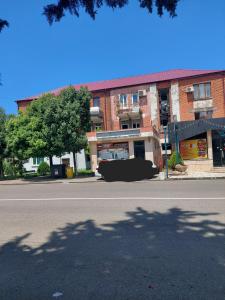 an empty street in front of a brick building at gegidze 24 in Poti