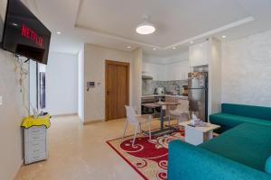 a living room with a blue couch and a kitchen at Solstice 73 Luffy Air Studio in Casablanca