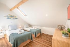 a attic room with two beds and a table at Guestready - Alma Nossa – Alma do Mar in Montijo