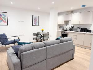 a living room with a couch and a kitchen at The Apollo Apartments in Saint Neots