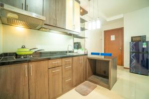 eine Küche mit Holzschränken und einer gelben Schüssel auf der Theke in der Unterkunft 1BR Near GI Mall Thamrin SCBD2 in Jakarta