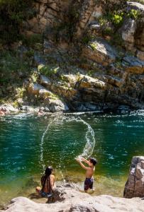 zwei Kinder spielen im Wasser eines Flusses in der Unterkunft Balcones del Rio in Santa Rosa de Calamuchita
