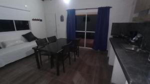 Zimmer mit einem Tisch, Stühlen und einem Sofa in der Unterkunft Balcones del Rio in Santa Rosa de Calamuchita