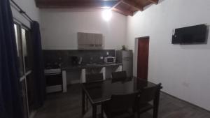 eine Küche mit einem Tisch und eine Küche mit einer Mikrowelle in der Unterkunft Balcones del Rio in Santa Rosa de Calamuchita