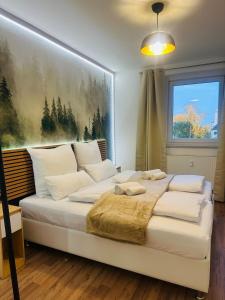 a bedroom with a white bed with a painting on the wall at YAYstay - Forest I 65m2 I Balcony I TV I Bahnhof in Mühldorf