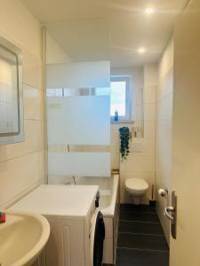 a white bathroom with a sink and a toilet at YAYstay - Forest I 65m2 I Balcony I TV I Bahnhof in Mühldorf +15 photos