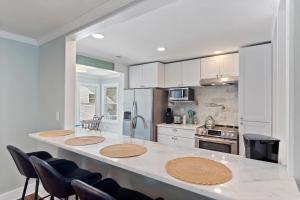a kitchen with a large white counter top with chairs at AV4-22: 4 22nd Avenue in Isle of Palms