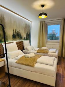 two beds in a room with a painting on the wall at YAYstay - Forest I 65m2 I Balcony I TV I Bahnhof in Mühldorf